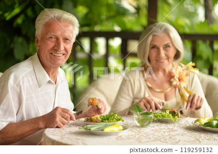 Happy senior couple having diner and posing at home Happy senior couple having diner and posing at home 119259132