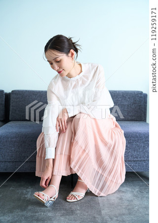 A woman sitting on a sofa A woman sitting on a sofa 119259171