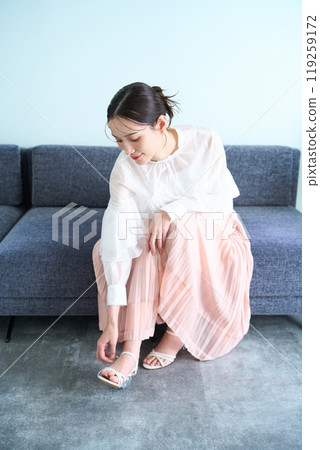 A woman sitting on a sofa 119259172