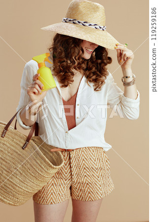 smiling trendy woman in blouse and shorts on beige smiling trendy woman in blouse and shorts on beige 119259186
