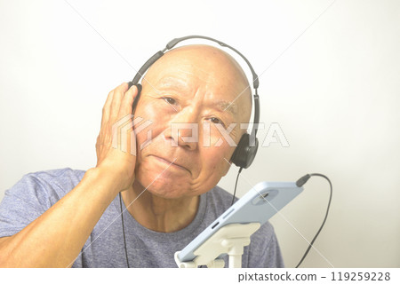 微笑的老人在智慧型手機上享受音樂 微笑的老人在智慧型手機上享受音樂 119259228