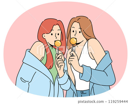 Two women with chupa chups in hands dressed in fashionable seductive clothes eat lollipops Two women with chupa chups in hands dressed in fashionable seductive clothes eat lollipops 119259444