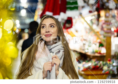 Girl stands in middle of shopping area decorated for New Year holidays 119259918