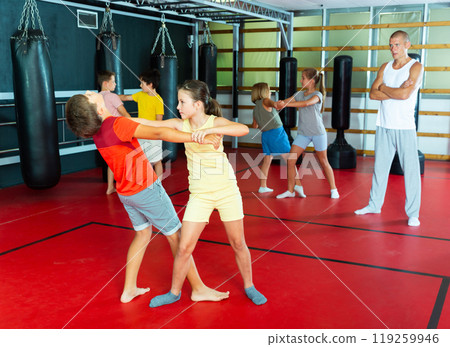 Kids in pair exercising self-defense movements Kids in pair exercising self-defense movements 119259946