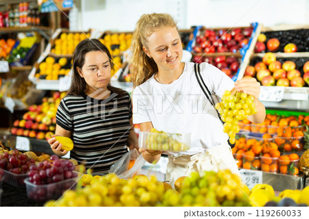 Teenage girl and her mother buying grape at grocery Teenage girl and her mother buying grape at grocery 119260033