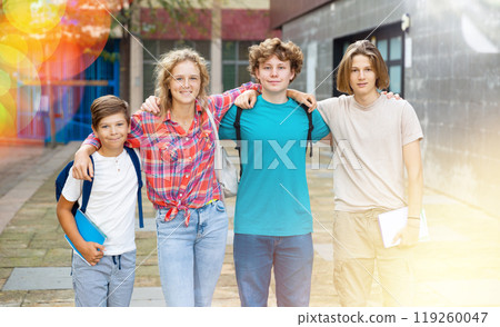 Group of positive cheerful teenagers hanging out on streets of city on day Group of positive cheerful teenagers hanging out on streets of city on day 119260047