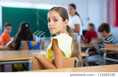 Portrait of girl in classroom during lesson Portrait of girl in classroom during lesson 119260190