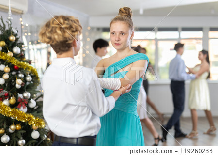 Teenage girl dancing ballroom dance with boy during New Year party 119260233