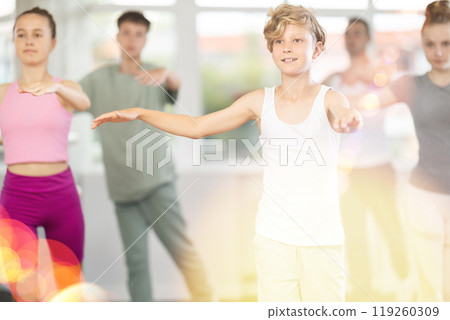 Teenage boy practicing ballet positions in dance studio 119260309