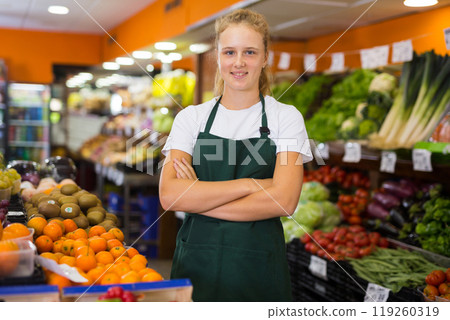 Portrait of a smiling girl who works part-time in a store as a trainee saleswoman 119260319