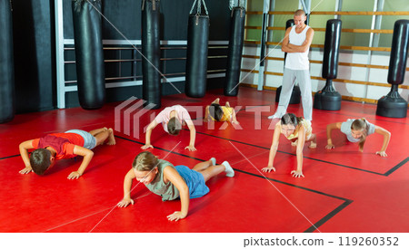 Preteen girls and boys are doing push-ups 119260352