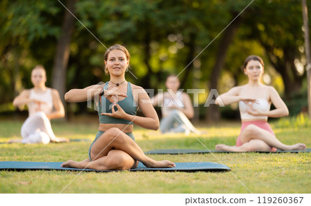 Yoga lesson visitors girls perform Gomukhasana in park 119260367