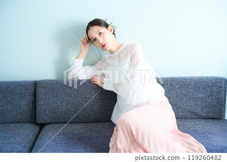 A woman sitting on a sofa A woman sitting on a sofa 119260482