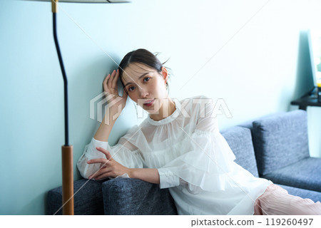A woman sitting on a sofa 119260497
