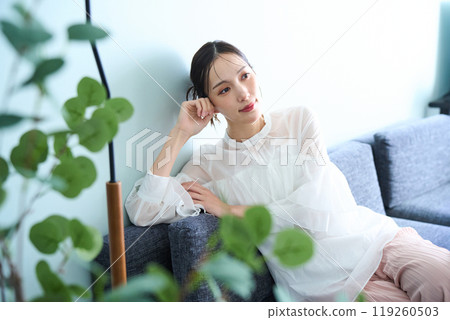 A woman sitting on a sofa A woman sitting on a sofa 119260503
