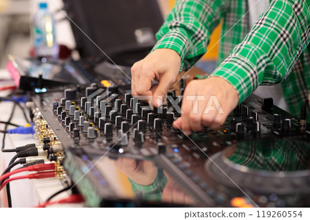 close-up of a DJ mixing music on a mixing console 119260554