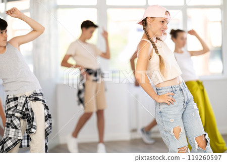Active teenagers practicing hip hop dance in training hall during group dancing classes 119260597