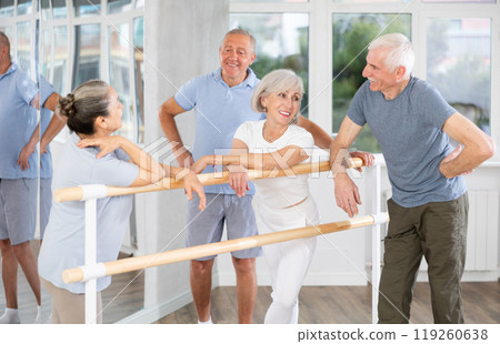 Elderly ballet lovers communicate with each other during break between classes in choreographic studio 119260638
