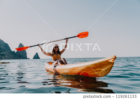 Kayaking, Woman, Ocean - Happy woman kayaking in a golden kayak on a sunny day. 119261133