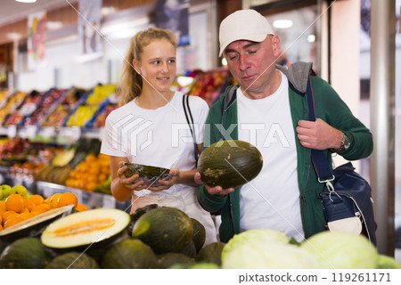 Father and his teenage daughter doing grocery shopping 119261171