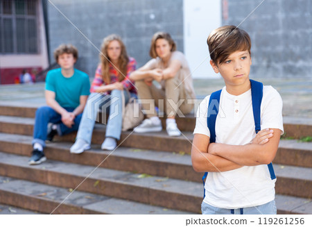 Sad school boy and bullies 119261256