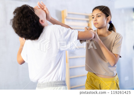 Boy and girl practicing self-defense techniques Boy and girl practicing self-defense techniques 119261425