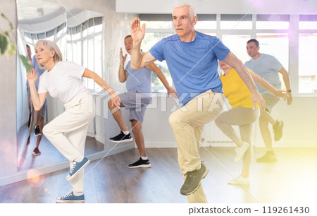 Elderly man learning dynamic dances at group choreography lesson Elderly man learning dynamic dances at group choreography lesson 119261430