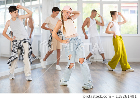 Active teenagers practicing hip hop dance in training hall during group dancing classes 119261491