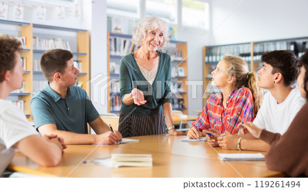 Brainstorming teenagers students and elderly teacher at library Brainstorming teenagers students and elderly teacher at library 119261494
