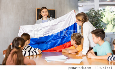 Teacher showing Russia flag to group of schoolchildren 119261551