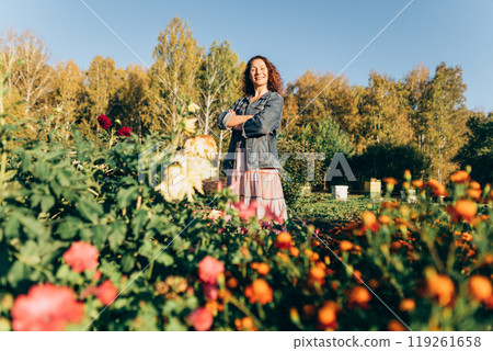 Woman gardener embracing the beauty of nature on her sustainable homestead. Plant lover in her element: enjoying the beauty of nature and sustainability on her land Woman gardener embracing the beauty of nature on her sustainable homestead. Plant lover in her element: enjoying the beauty of nature and sustainability on her land 119261658