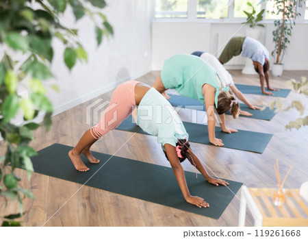 Training yoga kids on yoga mat in gym. 119261668