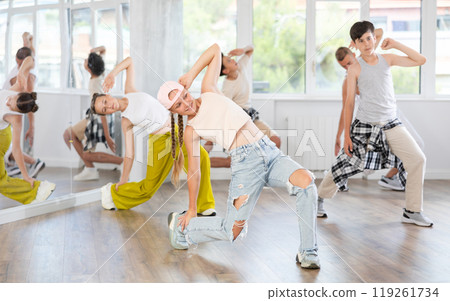 Girl in baseball cap with two hair pigtails with group of teenage friends, learn to dance hip hop 119261734