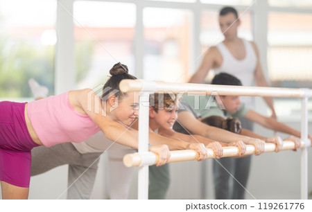 Teenagers ballet lovers learn to perform arabesque pose in choreography studio 119261776