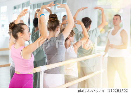 Ballet lesson for teenagers - choreographer teaches girls and boys ballet steps in studio Ballet lesson for teenagers - choreographer teaches girls and boys ballet steps in studio 119261792