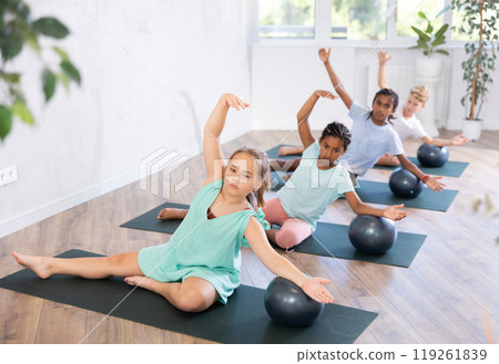 Kids doing pilates with softball. Kids doing pilates with softball. 119261839