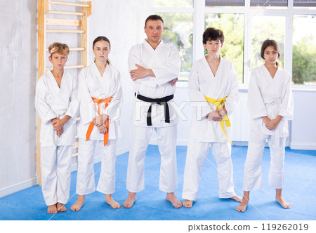 Group of children and karateka trainer posing in studio Group of children and karateka trainer posing in studio 119262019