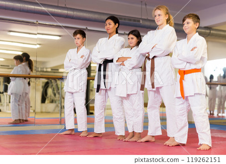 Group photo of kids and karate trainer in gym Group photo of kids and karate trainer in gym 119262151