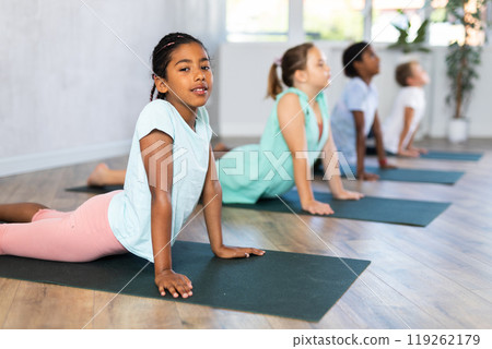 Baby cobra pose in yoga studio. 119262179