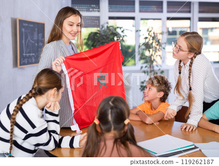 Female teacher shows scholchildren national flag of Morocco 119262187