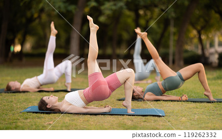 Group of young women doing yoga in park Group of young women doing yoga in park 119262332