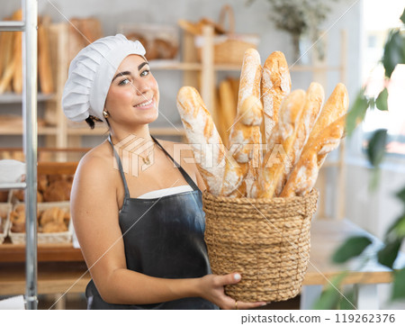 Young female seller with baguettes in basket 119262376