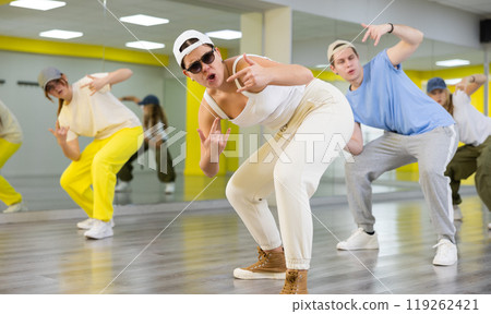 Young girl in sunglasses training breakdance Toprock moves in dance hall Young girl in sunglasses training breakdance Toprock moves in dance hall 119262421