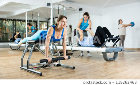 Young woman practicing pilates exercises on combo chair Young woman practicing pilates exercises on combo chair 119262468