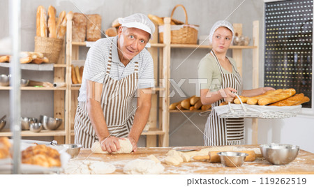 Male and female bakers working in bakery in workshop Male and female bakers working in bakery in workshop 119262519