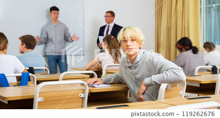 Young teenager is sitting at the desk in classroom Young teenager is sitting at the desk in classroom 119262676