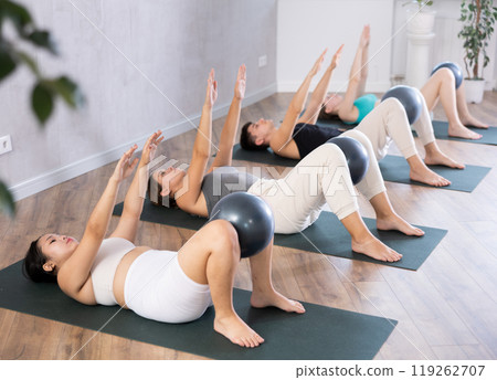 Asian girl participates in group lesson with softball, modern sport in studio. Asian girl participates in group lesson with softball, modern sport in studio. 119262707