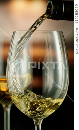 Close-up of white wine pouring into glass , freeze motion. 119263039