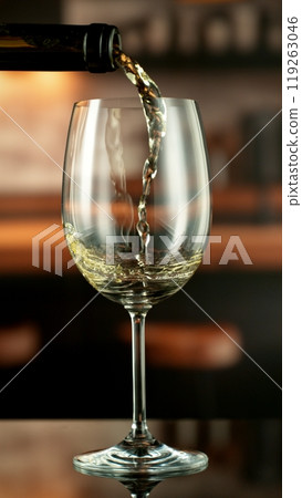 Close-up of white wine pouring into glass , freeze motion. 119263046