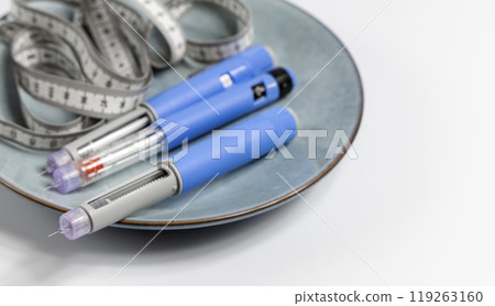 Ozempic Insulin injection pen for diabetics and weight loss on a plate with a measuring tape 119263160